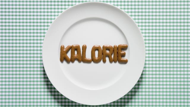 Auf einem Teller ist aus Russisch Brot das Wort "Kalorie" gebildet.