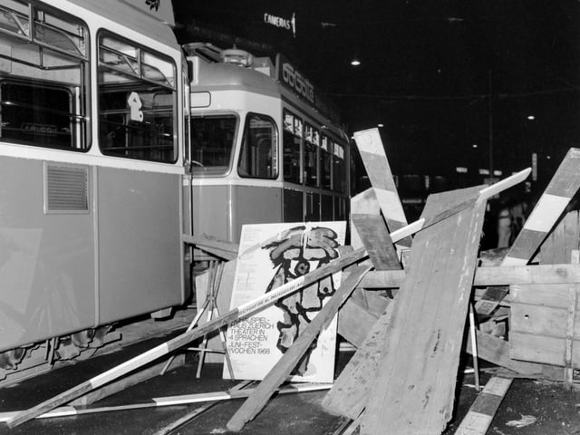 Eine Strassenbarrikade versperrt eine Strasse neben einem Tram..