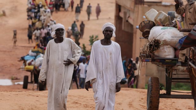 Sudanesische Männer überqueren die Grenze Sudan/Tschad.