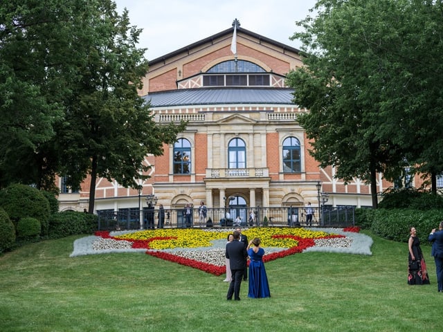 Herrschaftliches Backstein-Haus mit Garten und farbigen Blumen im Vordergrund