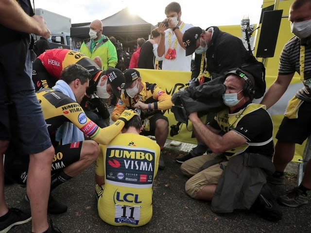 The destroyed Primoz Roglic is comforted by his teammates after the time trial.