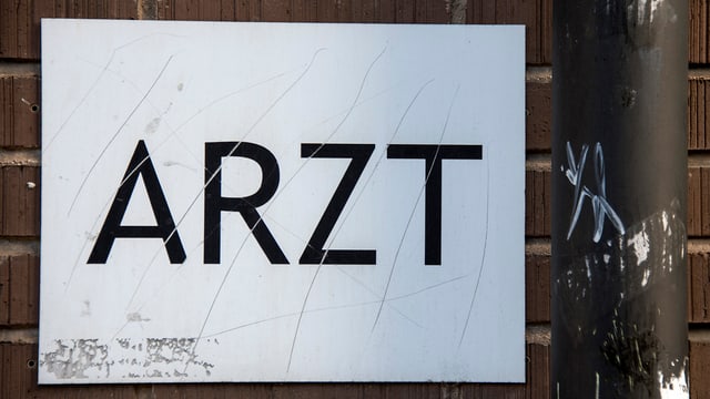 Ein Schild auf dem "Arzt" steht. 