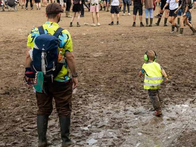 Ein grösserer und ein kleinerer Mensch stehen im Schlamm am Openair St. Gallen