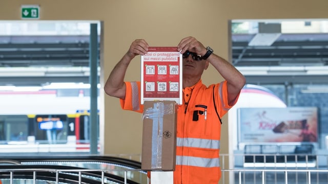 Railroad employees install disinfectant dispensers