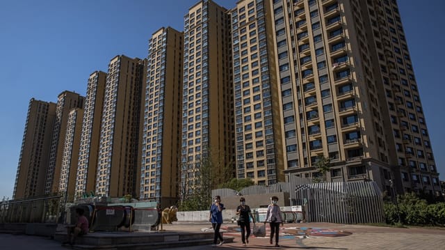 Menschen vor einem Gebäude des Immobilienkonzerns Evergrande in Beijing.