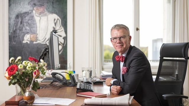 Paul Seger sitzt an einem Tisch in seinem Büro.