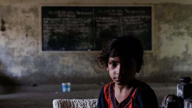 Ein pakistanisches Mädchen sitzt in einer verlassenen Schule, um dort Schutz vor den Fluten zu finden.