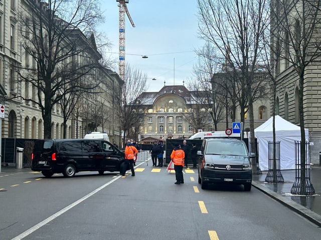 Abgesperrte Strasse, dahinter Bundeshaus. Zwei Personen in oranger Weste