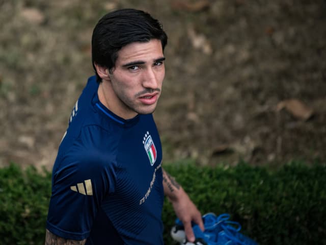 Fussballspieler in blauem Trikot schaut in die Kamera.