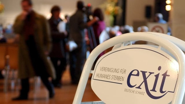 Eine Tafel mit dem Exit-Logo steht am Eingang eines Saales 