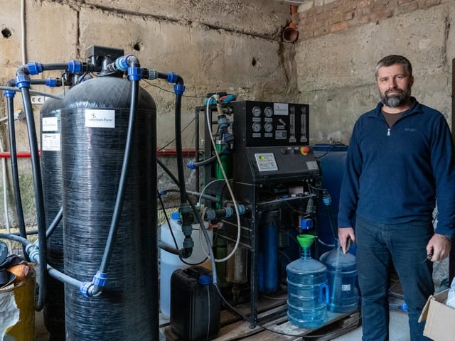 Mann steht neben Wasseraufbereitungsanlage.