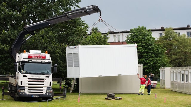 Ein Kran stellt in Hamburg Wohncontainer für Flüchtlinge auf.