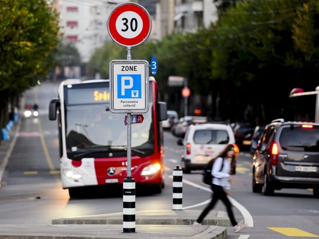 Bus hinter einer 30er-Zone-Tafel