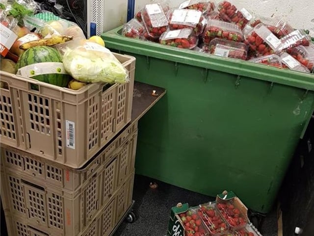 Container gefüllt mit Erdbeeren. Daneben Kisten mit weiteren Erdbeeren und diversen Früchten.