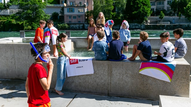 Die Schülerinnen und Schüler baden ihre Füsse im warmem Brunnenwasser.