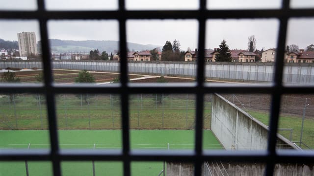 Der Blick ins Freie durch die Gitterstäbe einer Gefängniszelle.