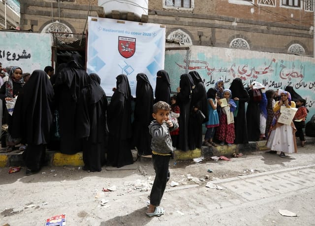 Verschleierte Frauen und Kinder stehen an.