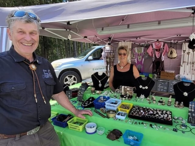 Ein Mann und eine Frau stehen vor einem Schmuckstand.