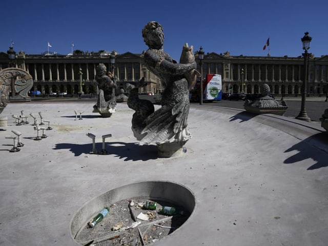 Ein leerer Brunnen. Im Hintergrund der Place de la Concorde in Paris.