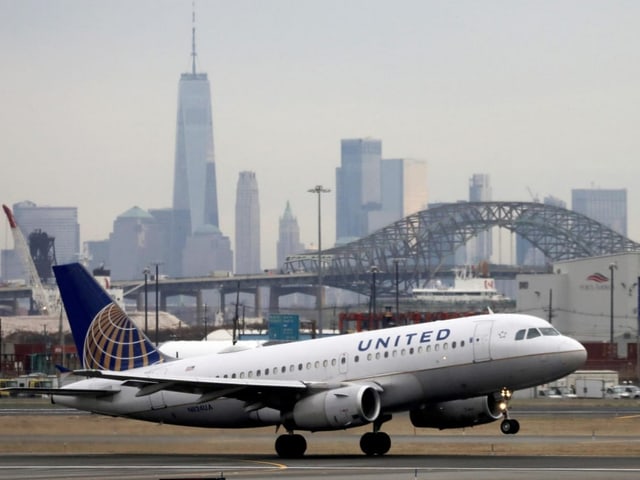 Flugzeug der United Airlines auf dem Rollfeld mit Skyline im Hintergrund.