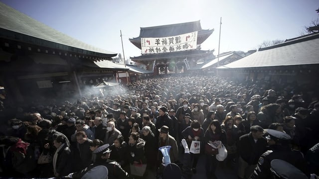 Dense crowd, temples in the background. 