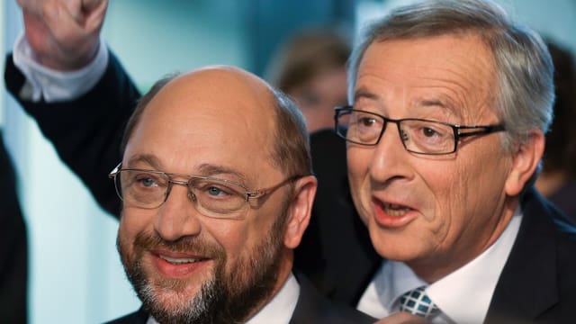 Juncker steht hinter Schulz und hält die rechte Faust in die Luft.