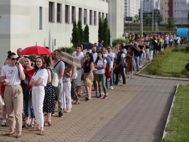 Eine lange Menschenschlange wartet darauf, dass sie abstimmen können.