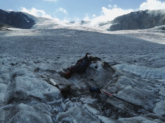 Auf dem Gletschereis liegen Überreste eines Menschen und Teile seiner Bergsteigerausrüstung.