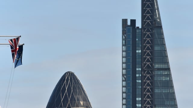 Zwei Wolkenkratzer neben einer EU- und einer Grossbritannien-Flagge.