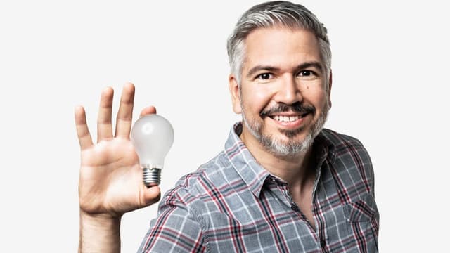 Moderator Krispin Zimmermann mit einer Glühbirne in der Hand