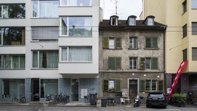 Ein sanierungsbedürftiger Altbau zwischen zwei Neubauten