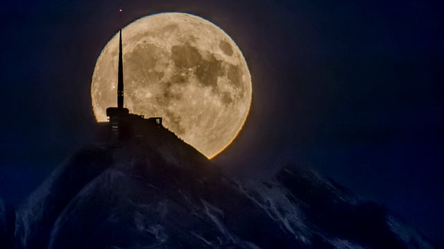 Vollmond vor der Bergspitze des Säntis.