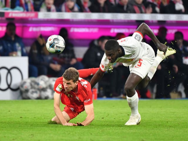 Thomas Müller (left) fights for the ball with Dayot Upamecano from Leipzig.