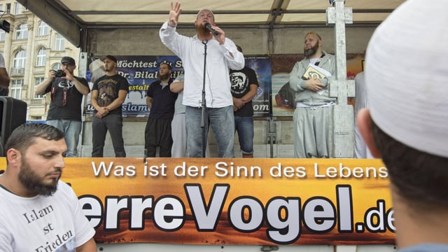 Der Salafistenprediger Pierre Vogel spricht auf einer Bühne.