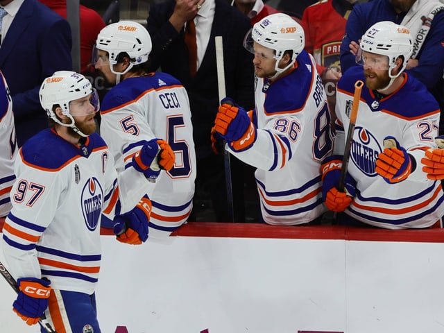 Eishockeyspieler der Edmonton Oilers feiern auf der Bank.