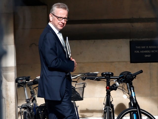 Micheal Gove steht neben Fahrrädern