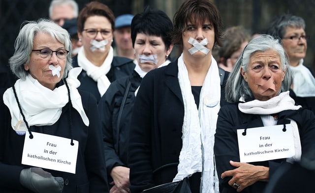 Frauen protestieren: ihre Münder sind mit Klebeband zugeklebt.