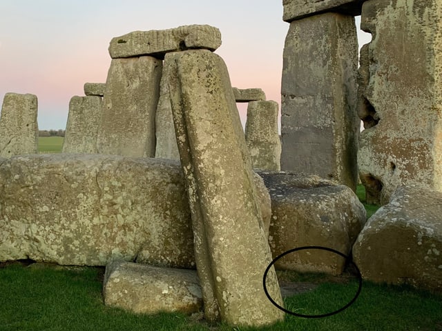 Detailaufnahme von Steinen des Stonehenge mit grünem Gras im Vordergrund.