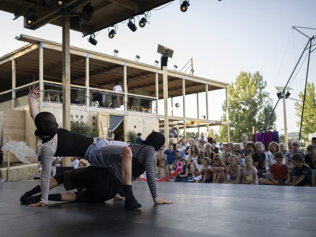 Zwei Künstler führen eine Contemporary-Dance-Performance vor einem Publikum auf.