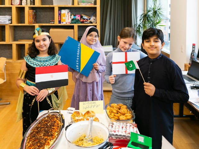 Lien (Ägypten), Sarah (Bosnien), Eva (England) und Haris (Pakistan) zeigen stolz ihren Spezialitätentisch. 