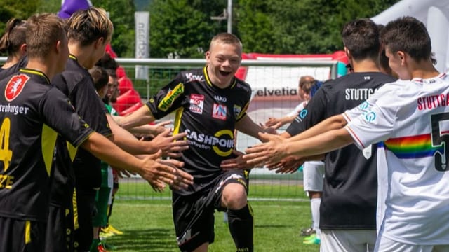 Fussballspieler mit und ohne Beeinträchtigung feiern einen Sieg