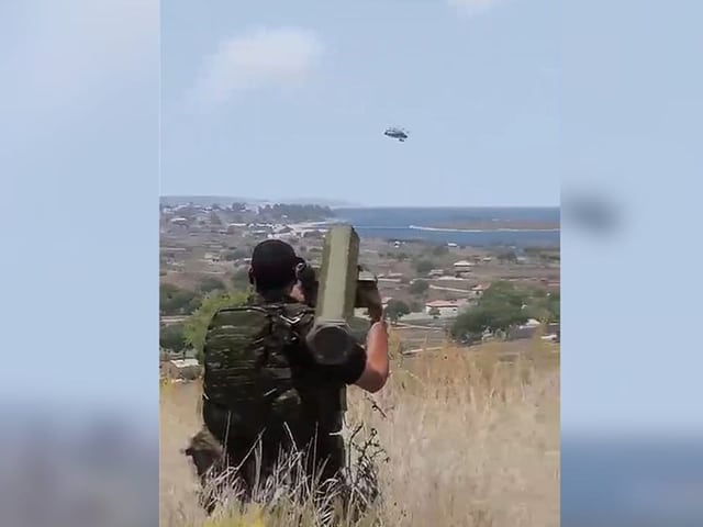 Fast fotografisches Bild eines Mannes in Armeekleidung mit riesigem Abschussrohr auf der Schulter, schiesst in Himmel.