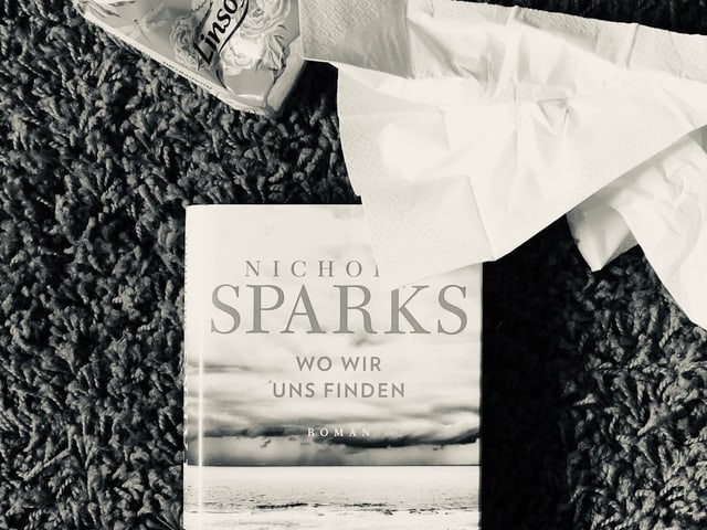 Der neue Roman von Nicholas Sparks: «Wo wir uns finden» liegt auf dem Teppich, zerknüllte Nastücher daneben