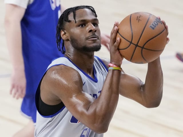 Basketballspieler in der Wurfbewegung auf dem Spielfeld.