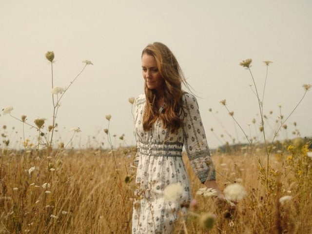 Frau in einem Feld voller Wildblumen.