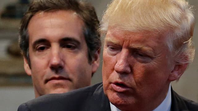 Trump steht vor Cohen und spricht.