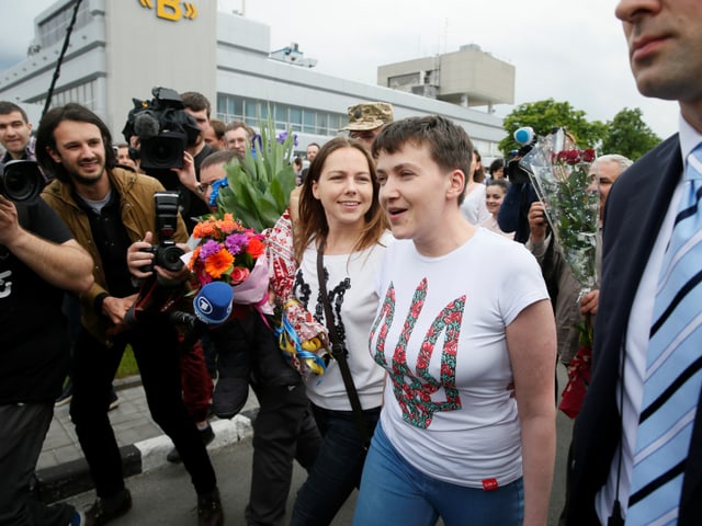 Zwei Frauen, umlagert von Journalisten. 