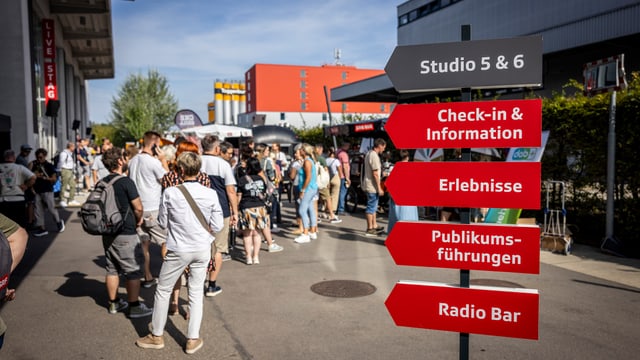 Ein roter Wegweiser weist den besuchenden den Weg zu den Studios und den Programmpunkten.