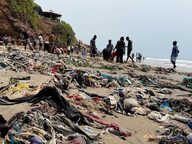 Auf einem Sandstrand liegen unzählige Kleidungsstücke