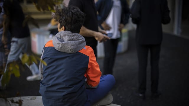 Ein junger Mann sitzt im Bundesasylzentrum in Zürich.